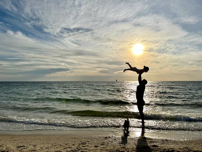 Matilda Hart, 2, has fun in the shallows of Bonbeach Beach with dad and puppy Poppy after her dad finished work early and was able to make it home for a family walk. Picture: April Hart, Bonbeach.