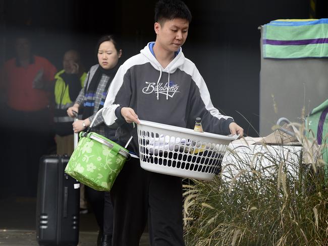 Residents are seen carrying their personal items out of the Mascot Towers. Picture: AAP