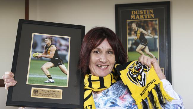 Dustin Martin’s proud mum, Kathy, holds framed photos of her AFL star son in action. Picture: David Caird