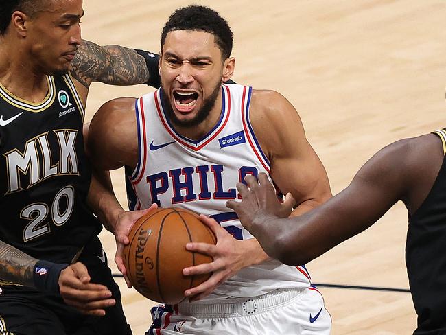 ATLANTA, GEORGIA - JUNE 18:  Ben Simmons #25 of the Philadelphia 76ers drives between John Collins #20 and Clint Capela #15 of the Atlanta Hawks during the first half of game 6 of the Eastern Conference Semifinals at State Farm Arena on June 18, 2021 in Atlanta, Georgia.  NOTE TO USER: User expressly acknowledges and agrees that, by downloading and or using this photograph, User is consenting to the terms and conditions of the Getty Images License Agreement. (Photo by Kevin C. Cox/Getty Images)