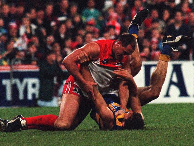 Tony Lockett and Fraser Gehrig wrestle during a 1997 Sydney Swans v West Coast Eagles AFL game.