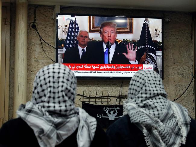 Palestinian men watch Donald Trump’s address at a cafe in Jerusalem. Picture: AFP/Ahmad Gharalbi