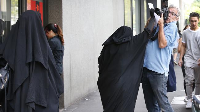 A woman dressed in a niqab lashing out at a photographer. Picture: David Caird