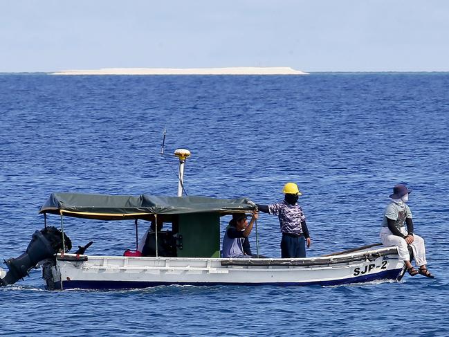 Eengineers from NAMRIA, the central mapping agency of the Philippine Government, survey the area around the Philippine-claimed Thitu Island with a sandbar sitting on the horizon off the disputed South China Sea in the western Philippines. Picture: AP