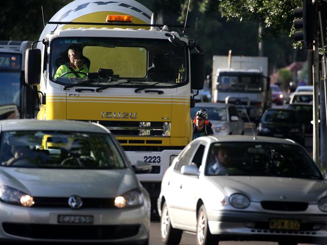 A bike rider negotiates heave traffic in Randwick. Motorists must give bike riders a 1m plus berth under new laws. Picture: John Grainger