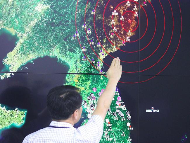 A South Korean official points to a map showing the epicentre of seismic waves in North Korea, at the Korea Meteorological Administration in Seoul. Picture: AFP / YONHAP