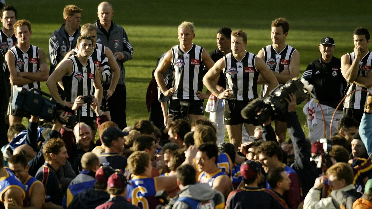 Collingwood players watch on in despair as Brisbane celebrate the 2003 premiership (Photo by Robert Cianflone/Getty Images)