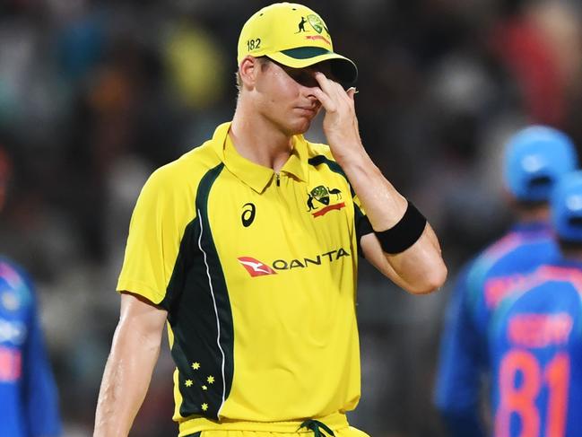 Australia's captian Steve Smith (C) reacts as Indian cricketers celebrate the wicket of Australia's Travis Head during the second one day international (ODI) match of the ongoing India-Australia cricket series at the Eden Gardens Cricket Stadium in Kolkata on September 21, 2017. / AFP PHOTO / Dibyangshu SARKAR / ----IMAGE RESTRICTED TO EDITORIAL USE - STRICTLY NO COMMERCIAL USE----- / GETTYOUT