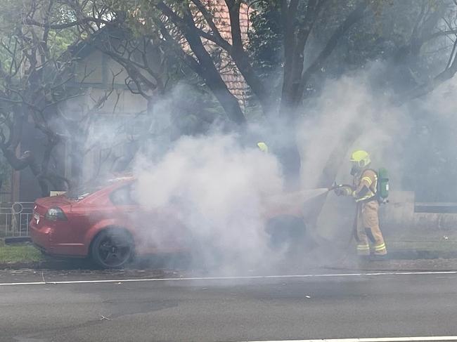 Firefighters worked fast to put out the flames as smoke billowed into the street. Picture: Len Walker