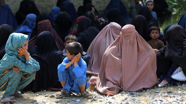 Afghan women and children wait to receive food aid on the outskirts of Jalalabad. Picture: AFP