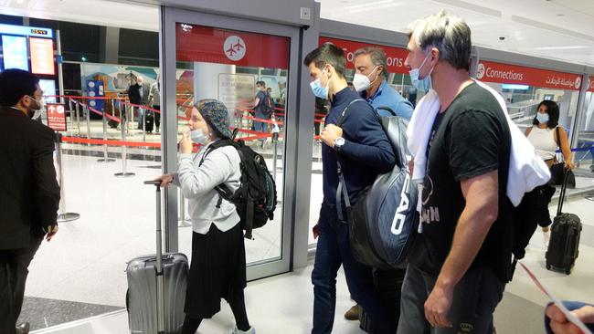 Serbian tennis player Novak Djokovic walks with his team after landing at Dubai Airport. Photo: REUTERS.