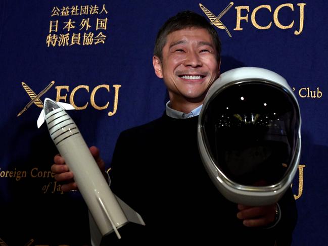 (FILES) This file photo taken on October 9, 2018 shows Yusaku Maezawa, entrepreneur and then-chief of online fashion company Zozo and SpaceX BFR's first private passenger, poses with a miniature rocket and space helmet prior to start of a press conference at the Foreign Correspondents' Club of Japan in Tokyo. - A Japanese billionaire has launched an online wanted ad -- a girlfriend who will fly around the Moon with him on a SpaceX rocket. The deadline to apply is January 17, 2020. (Photo by Toshifumi KITAMURA / AFP)