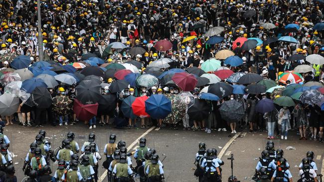 TOPSHOT - Protesters face off with police during a rally against a controversial extradition law proposal outside the government headquarters in Hong Kong on June 12, 2019. - Violent clashes broke out in Hong Kong on June 12 as police tried to stop protesters storming the city's parliament, while tens of thousands of people blocked key arteries in a show of strength against government plans to allow extraditions to China. (Photo by DALE DE LA REY / AFP)