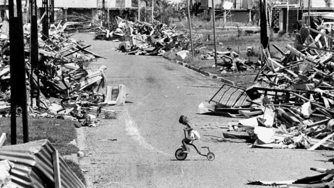 28 Dec 1974 Little girl, Poppy Magoulis (now Papazoglou) riding her bicycle on the street which was destroyed by Cyclone Tracy in Darwin 25 Dec. PicBruce/Howard weather nt storms damage wreckage