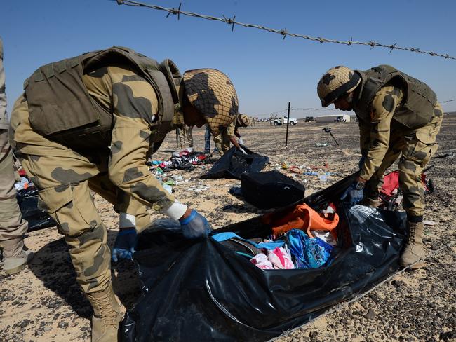 Aftermath ... Egyptian soldiers collect personal belongings of plane crash victims at the crash site of a passenger plane bound for St. Petersburg in Russia that crashed in Hassana, Egypt's Sinai Peninsula. Picture: AP