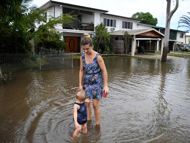 Belinda Strong and her 2-year-old daughter Alicia are seen outside their flood-affected house in Ingham in North Queensland. (AAP Image/Dan Peled)