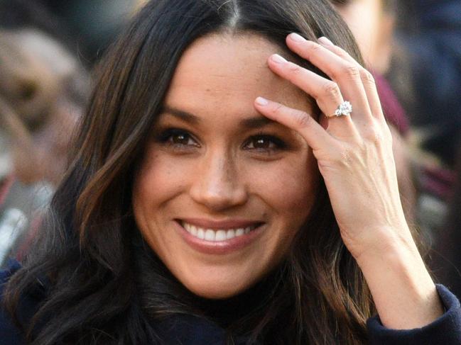 (FILES) This file photo taken on December 01, 2017 shows  Britain's Prince Harry's fiancee US actress Meghan Markle displaying her engagement ring as she greets wellwishers on a walkabout as they arrive for an engagement at Nottingham Contemporary in Nottingham, central England, which is hosting a Terrence Higgins Trust World AIDS Day charity fair. Meghan Markle is to become the first fiancee invited to spend Christmas with the British royal family -- a move hailed December 14, 2017, as a sea change in the monarchy's traditionalist attitude. / AFP PHOTO / Oli SCARFF