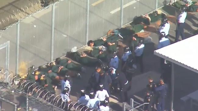 Prisoners are seen lying on the ground inside the complex. Picture: 9 News