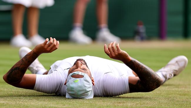 Nick Kyrgios falls to the ground after defeating Cristian Garin in their Wimbledon quarterfinal. Picture: Getty Images