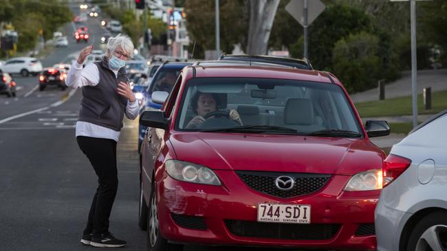 A motorist tries to reason with other drivers to move as queues of cars line up for Covid-19 testing at Caloundra on Wednesday afternoon. Picture: Lachie Millard