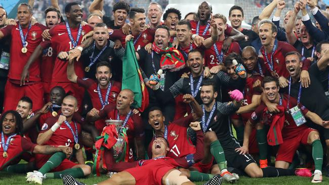 Portugal's forward Cristiano Ronaldo (C) and his teammates pose with the trophy.