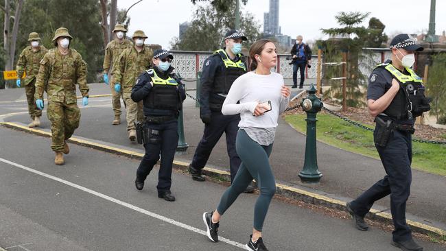 ADF personnel and police patrol along the Yarra in Melbourne on day one of the city’s mandatory mask-wearing. Picture: NCA NewsWire / David Crosling