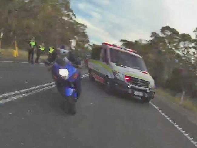 Body-worn camera image of a motorcyclist who rode at speed through the blocked-off scene of a fatal crash on the Bass Highway, narrowly missing emergency services workers. Picture: TASMANIA POLICE