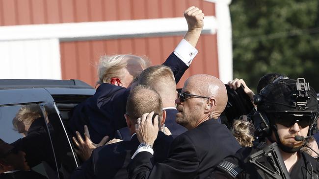 Former president Donald Trump pumps his fist as he is rushed into car after an assassination attempt in Butler, Pennsylvania. Picture: Anna Moneymaker/Getty Images/AFP