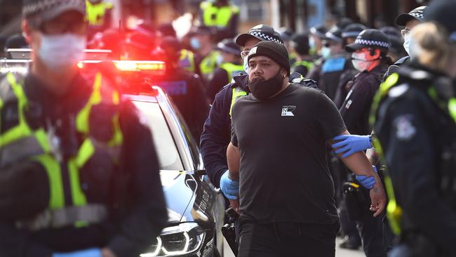 Police detain an anti-lockdown protester at Melbourne's Queen Victoria Market during a rally on September 13. Picture: AFP