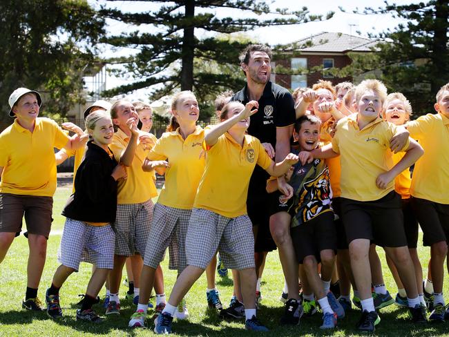 Former Richmond captain Chris Newman has a bit of fun with students from Warrnambool Primary school. Picture: Colleen Petch.