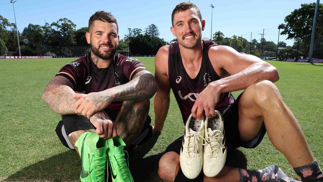 Adam Reynolds and Corey Oates with the boots that will be auctioned for Mater Little Miracles. Picture: Liam Kidston