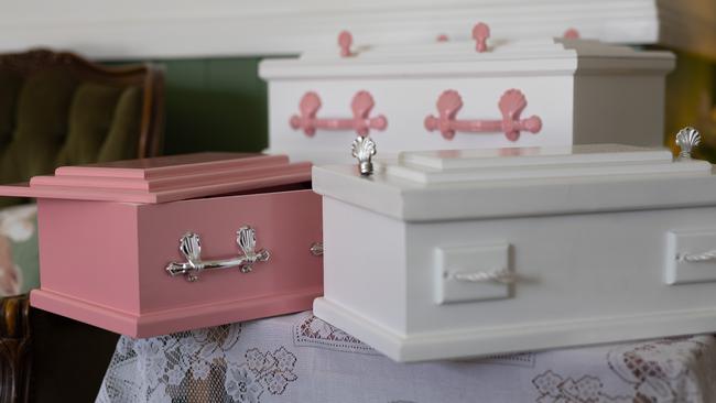 Handmade baby coffins line the shelf at Farewell Funerals in Meadowbrook. Picture: David Kelly