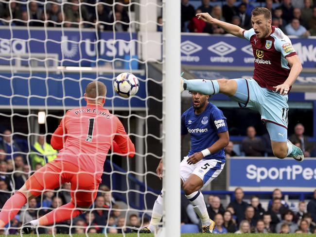 Everton goalkeeper Jordan Pickford in action as Burnley's Chris Wood tries to make a shot.