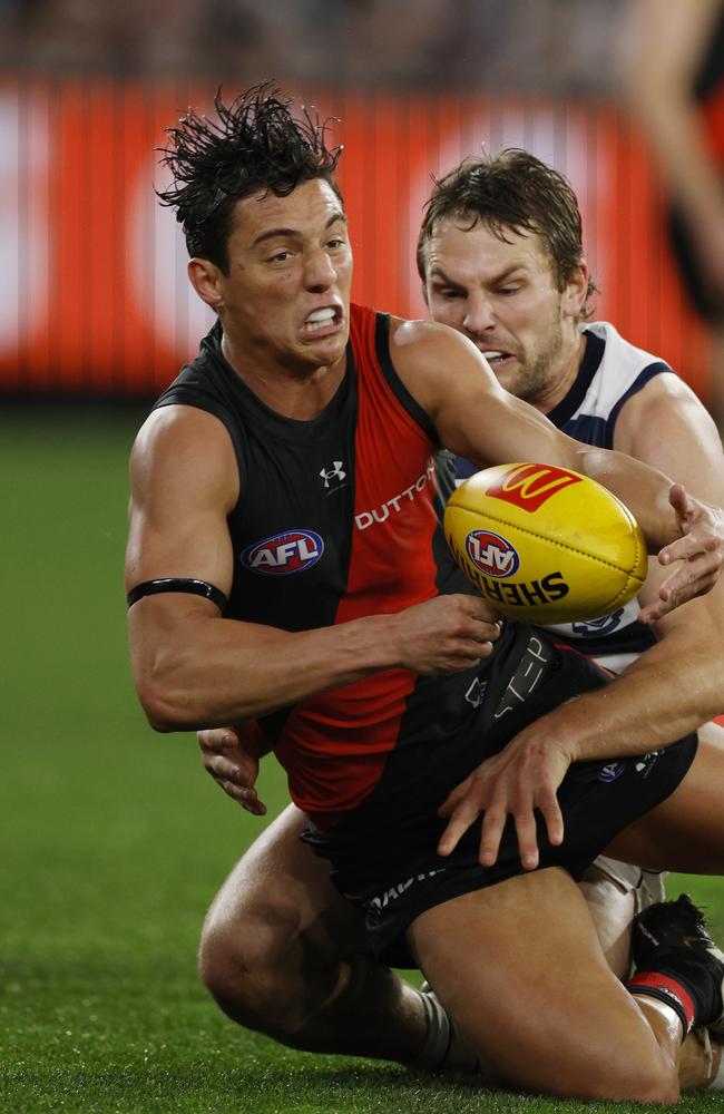 Jye Caldwell of the Bombers clears as he is tackled by Tom Atkins in the first quarter. Picture: Michael Klein