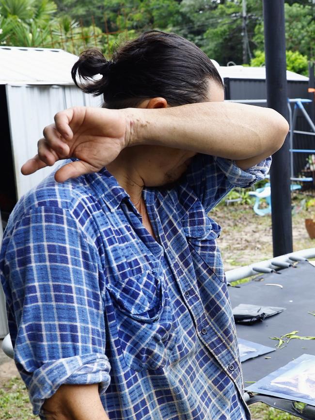 Chris "Kingy" King cries as he tries to save waterlogged photos of his wife and his children. Picture: Brendan Radke