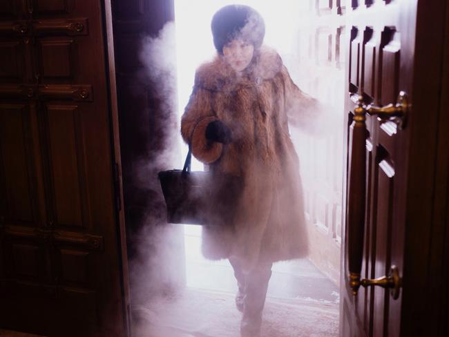 A local woman enters Preobrazhensky Cathedral in a swirl of freezing mist.