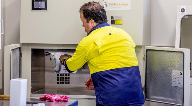 A machine is used to crush the remaining bones into 'ashes', before being transferred into the urn. Picture: Jerad Williams