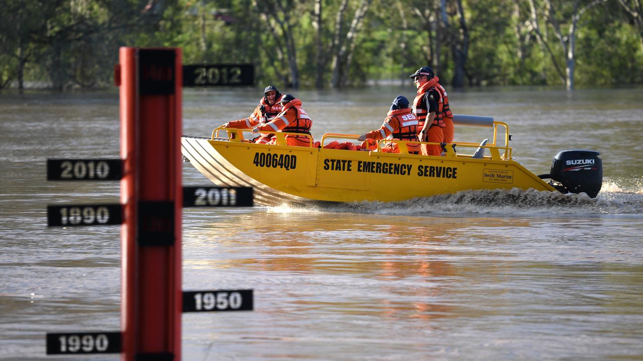 A State Emergency Service (SES) crew motors past a flood gauge on the swollen Balonne river in St George, southwestern Queensland. Photo: Dan Peled