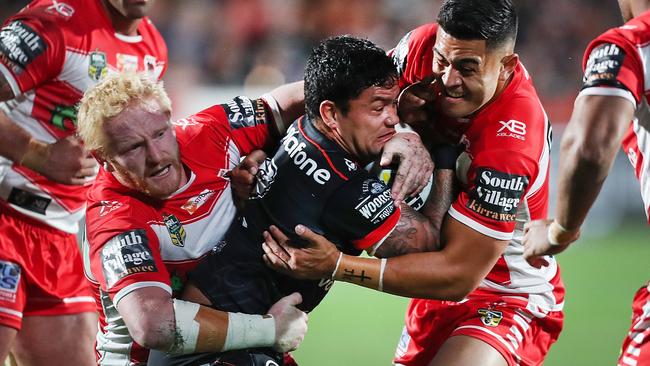 Issac Luke of the Warriors is tackled by James Graham (left) and Timoteo Lafai.