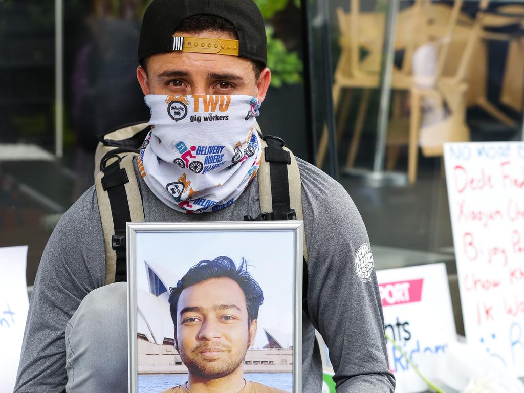 A delivery rider attending a protest in Sydney last year holds up a picture of a colleague killed on the job. Picture: NCA NewsWire / Gaye Gerard