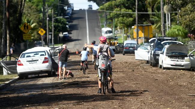 People tried to dry their cars out on what is NOT normally a dirt road in Narrabeen after flooding on Friday night. Picture: Jeremy Piper