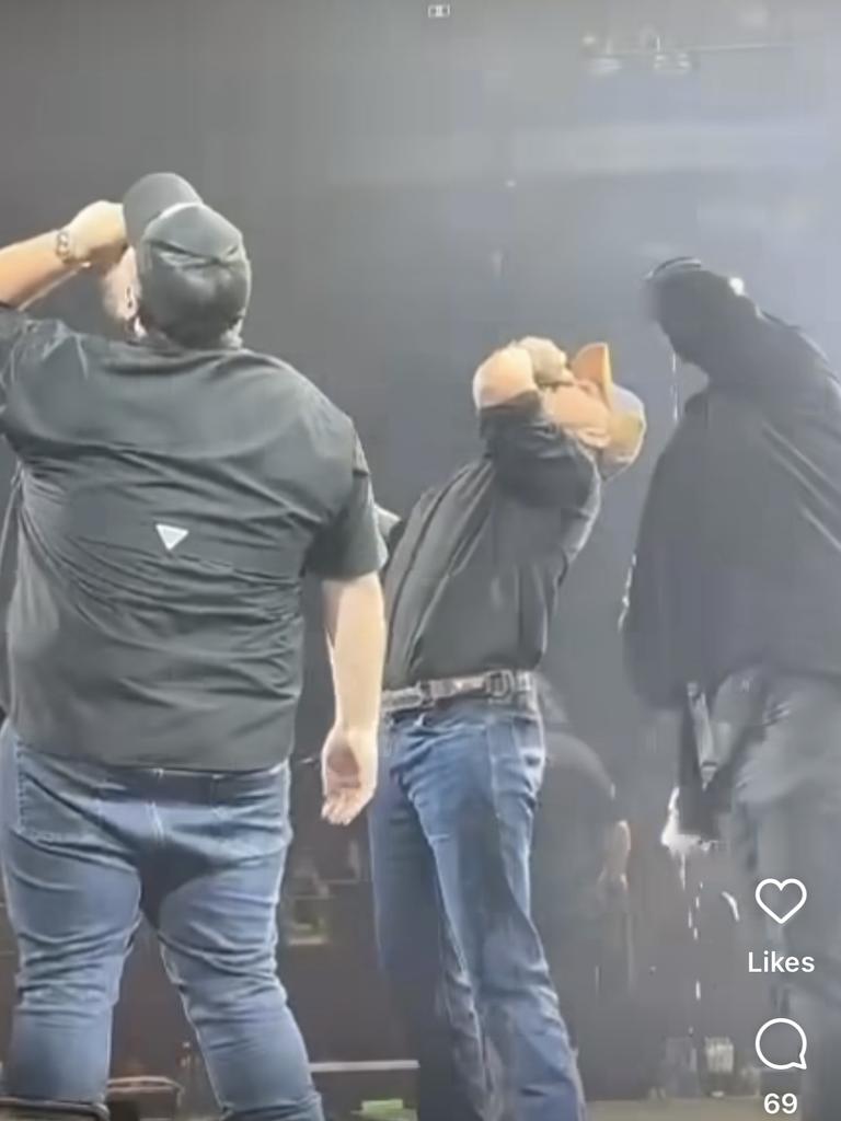 Latrell Mitchell and Tai Tuivasa shotgun a beer with Luke Combs at the American country singer's concert at Qudos Bank Arena on Wednesday night.