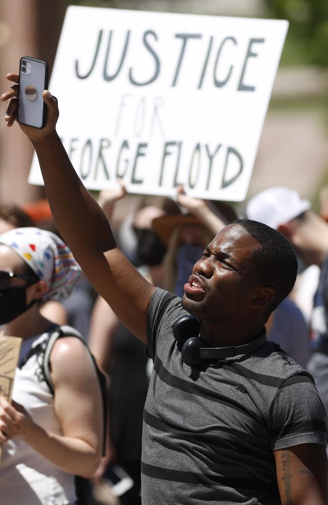 A man holds up his mobile device to record a protest outside the State Capitol in Denver. Picture: AP