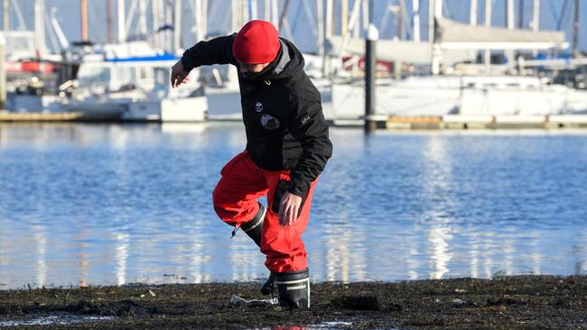 Sandringham Yacht Club Instructor Riccardo Deghi braves the soon to be removed black sludge. Picture: Penny Stephens