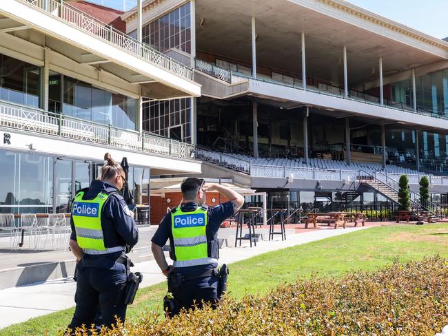 Police assess the scene at Caulfield Racecourse after a fire tore through the grandstand. Picture: Ian Currie