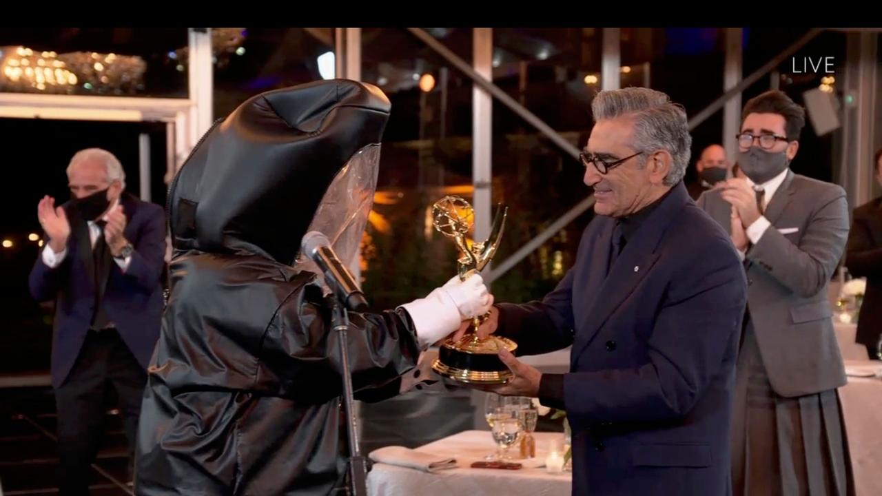 Canadian actor Eugene Levy received his Emmy for Outstanding Lead Actor in a Comedy Series for his work in Schitt’s Creek, from a presenter in a hazmat suit, while his son actor/director/writer Daniel Levy watches on. Picture: AFP