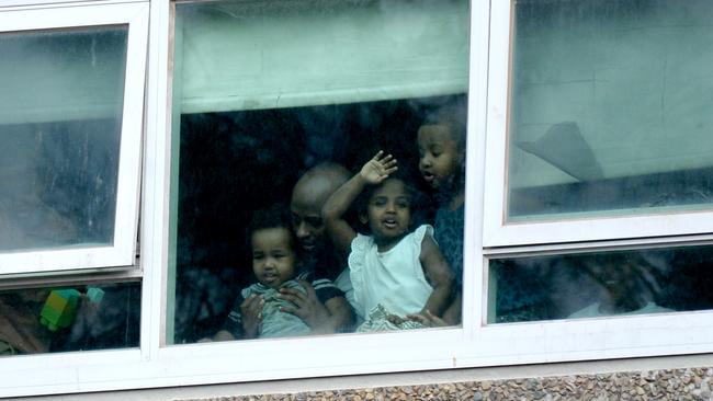 Residents look out from the North Melbourne public housing estate after it went into lockdown. Picture: Andrew Henshaw