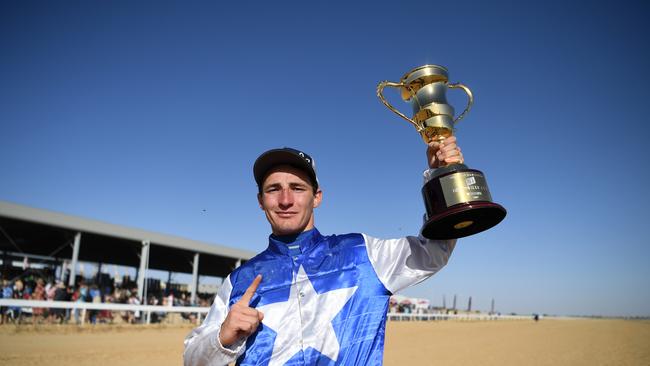 Jockey Clayton Gallagher celebrates after riding French Hussler to win the TAB Birdsville Cup Open Handicap in 2019. (AAP Image/Dan Peled).