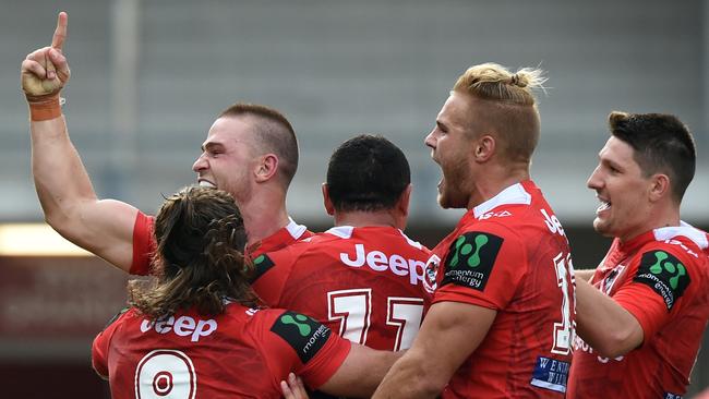 Euan Aitken (left) of the Dragons is congratulated after scoring a try.