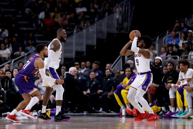 Bronny James (right) prepares to shoot as father LeBron James (left) looks on in the Los Angeles Lakers' pre-season game in Palm Desert on Sunday